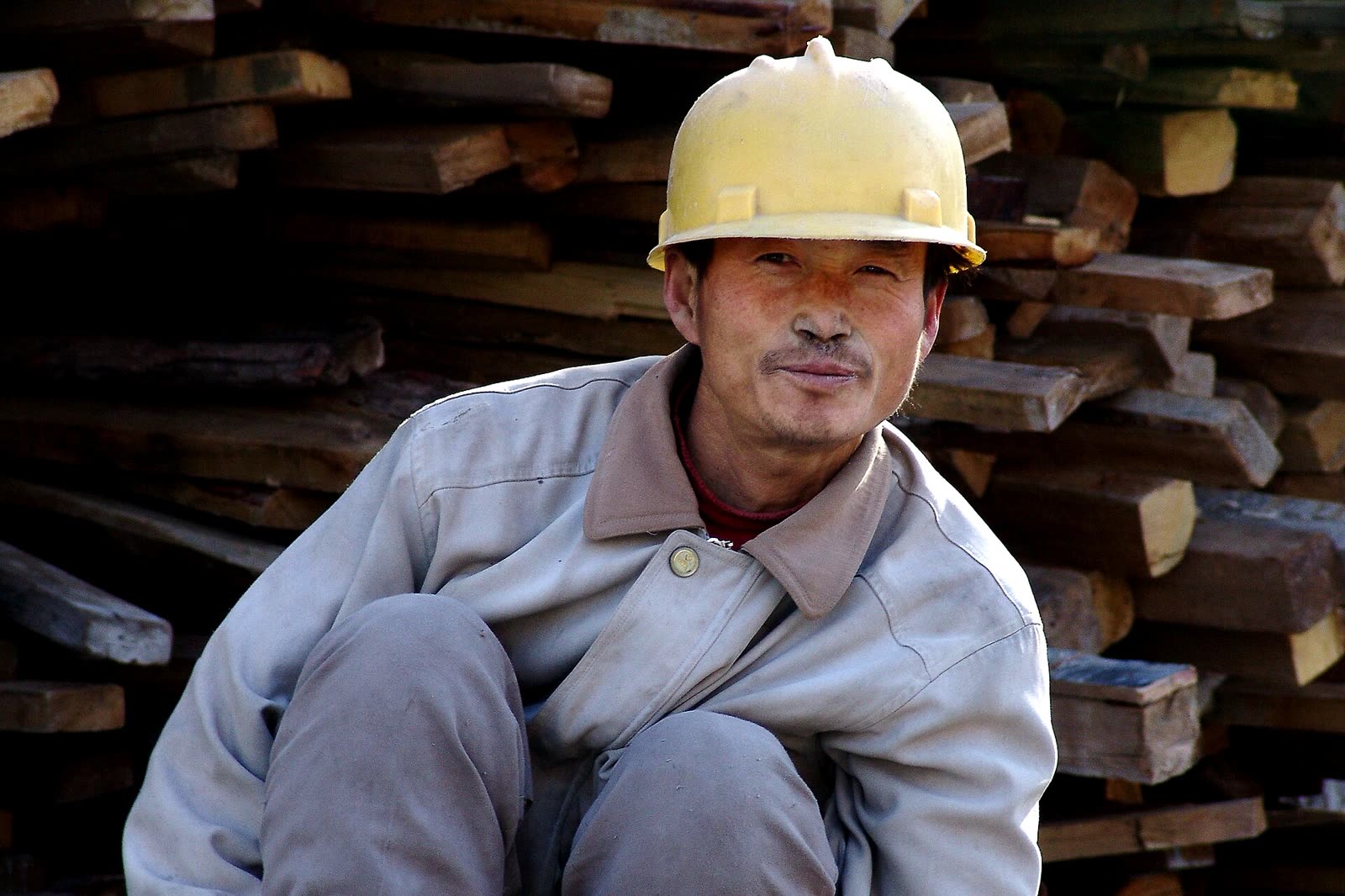 Mitarbeiter in Arbeitskleidung mit Schutzhelm